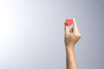 A man hand with wooden red heart object