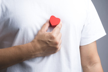 A man hand with wooden red heart object