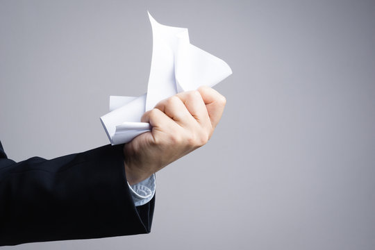 Business Man Hand  Crunching A Piece Of White Paper In Anger