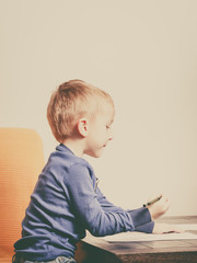Fototapeta premium Kid playing, drawing pictures on paper