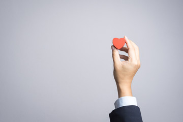 Business man hand with wooden red heart object