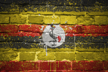 painted national flag of uganda on a brick wall