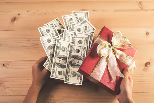 Money in red bow decorated gift box.