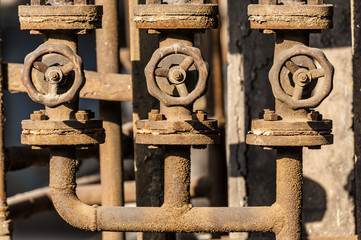 Three rusted valves and pipes