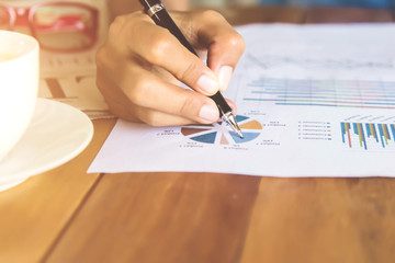 Business Male manager discussion ideas and writing business plan at workplace,man holding pens and papers for business data,notes documents,analysis chart at the table,vintage color,selective focus.