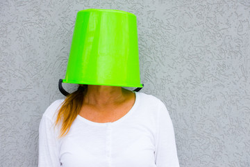 Woman with bucket over head hiding