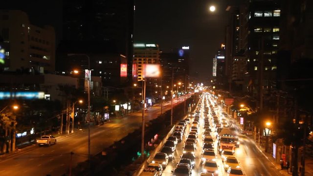 Moon rise above busy traffic in Bangkok, Thailand