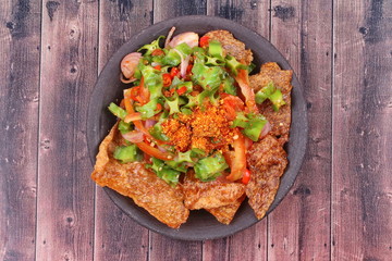 Spicy sour wing bean salad  with crispy pork served .