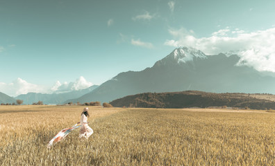 Girl running through the wheat farm