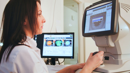 High technology health care - ophthalmologist in eyes clinic doing diagnostic with vision of patient by modern computer technology