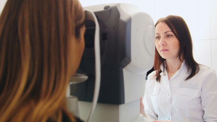 Ophthalmology clinic - optometrist checks patient's vision by modern electronic machine
