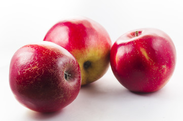Three red apples on a white background