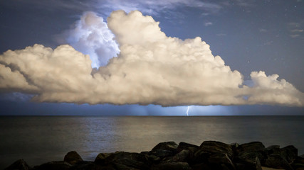 Nightime lightning strike from cloud into ocean