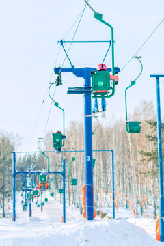 Skier climbs on the chair lift to the track