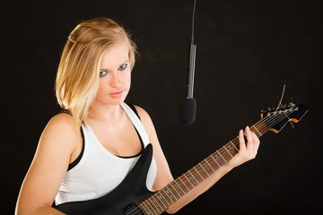 Woman playing on electric guitar and singing