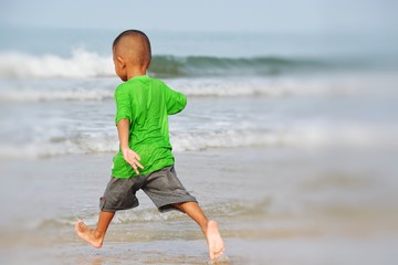 boy play neaf the sea