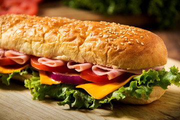 Sandwich with ham on a table, tomato and chees, homemade bread