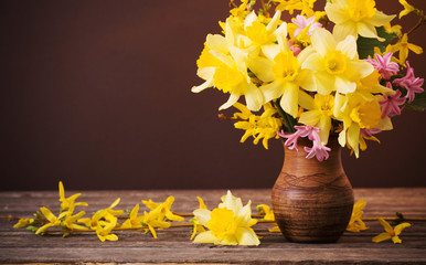 Daffodil in vase on brown background