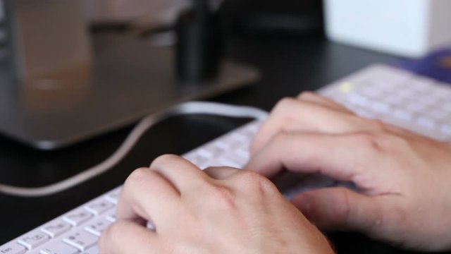 man typing on a white keyboard. hands closeup