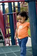 Little biracial girl playing at the park.