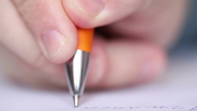 man writes with a ballpoint pen. Macro shooting