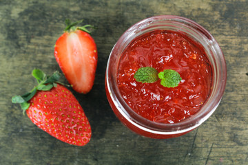 fresh strawberry jam in glass bottle with mint leaf