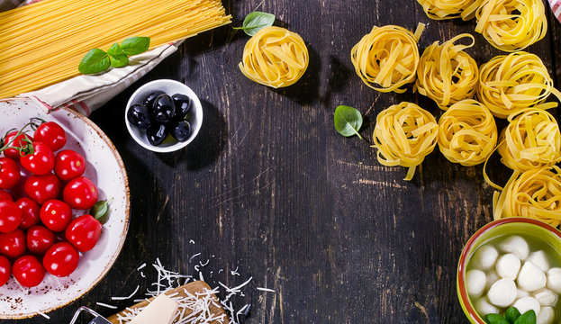 Italian food ingredients for cooking on a wooden background.