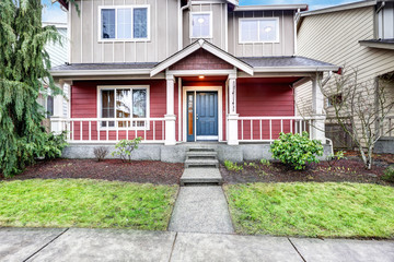 Fototapeta na wymiar Contemporary Red and grey home exterior with covered porch