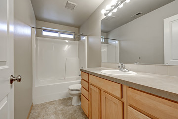 Grey bathroom interior with wood vanity cabinet