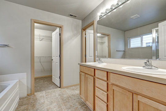 Grey bathroom interior with double sink wood vanity cabinet