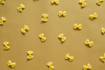 Pasta bow and spiral shape on brown background