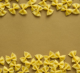 Pasta bow and spiral shape on brown background