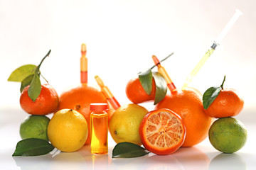 ampoules and Serum with Vitamin C. Organic cosmetics concept. Lemon, lime, orange, tangerine on a...