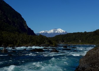 Fototapeta na wymiar The stunning blue and white waters of the petrohue river with Volcan Calbuco in the background near Saltos del Petrohue in Southern Chile