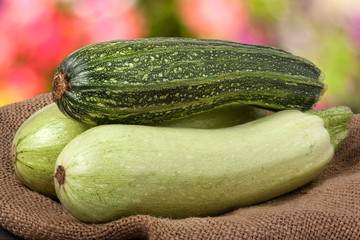 green zucchini and courgettes on sackcloth with a blurred background