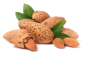 heap of almonds in their skins and peeled with leaf isolated on white background