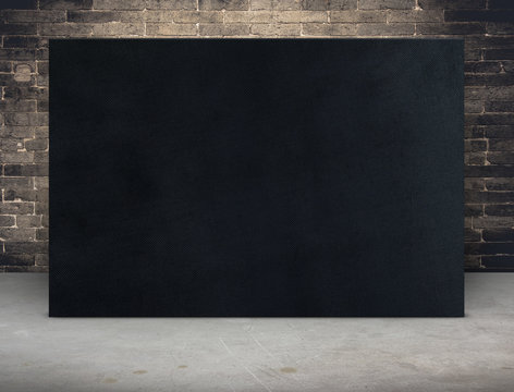 Blank black fabric canvas frame at grunge brick wall and concret
