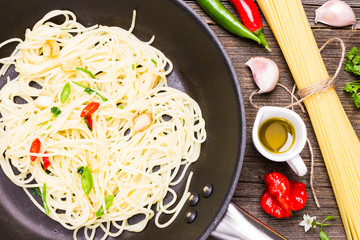 Spaghetti Aglio Olio e Peperoncino on Roasting Pan. Top View Italian Dish with Raw Cooking 