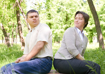 Unhappy couple in summer park. Face expression and grimace.