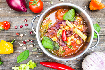 Mexican Cuisine. Bio Vegetable Soup with Chickpea and Adzuki Beans in Pot with Cooking Ingredients on Wooden Table Background