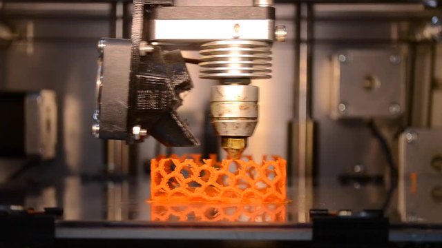 3d printer printing isolated Orange object close-up. The modern additive technology. The 4ht industrial revolution. Time lapse shot