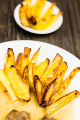 Baked French Fries with Sauce and Meat on White Plate