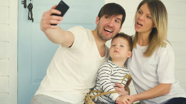 Father of happy family make selfie with his wife and little son in front their home door