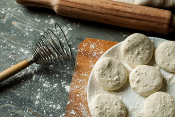 Homemade floured cookies with rolling pin and whisk on a wooden