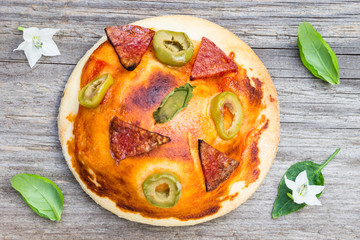 Top View Small Pizza with Salami, Olive and Basil Leaves on Wooden Background