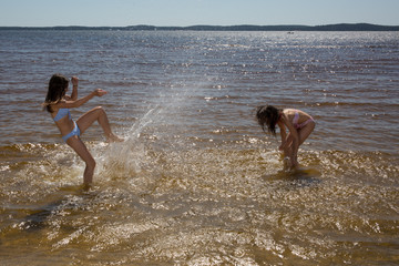Two girls, best friends having fun and splashing water
