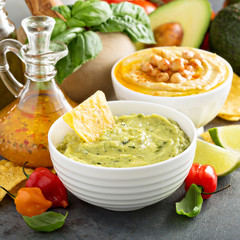 Guacamole and hummus in white bowls