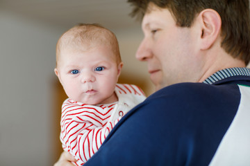 Happy proud young father with newborn baby daughter, family portrait togehter