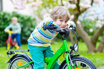 Adorable little kid boy driving his first bike or laufrad
