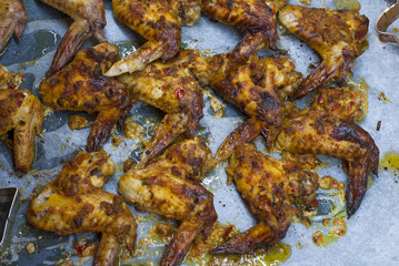 Hot and gold chicken wings with spicy sauce on oven tray